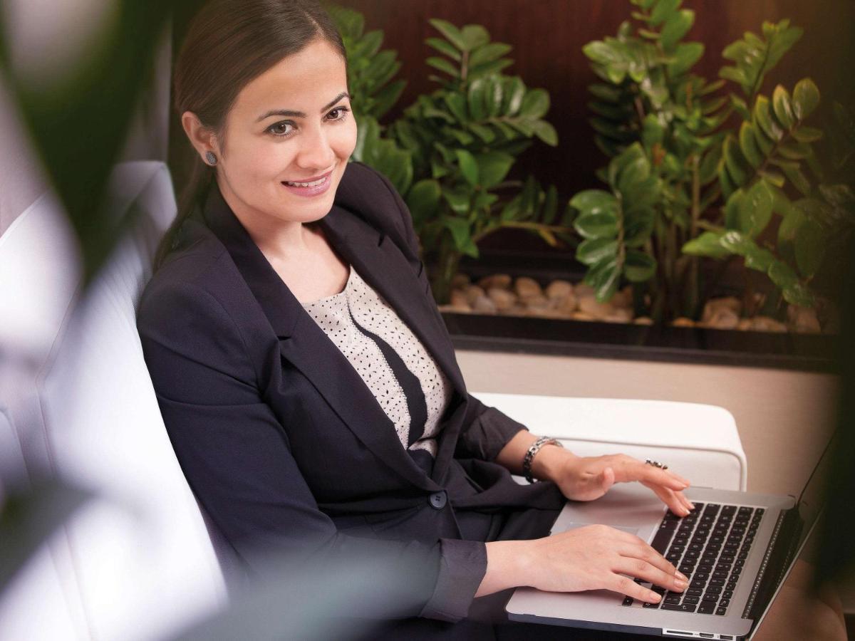 Movenpick Jumeirah Village Triangle Dubai Bagian luar foto A business woman working on a laptop